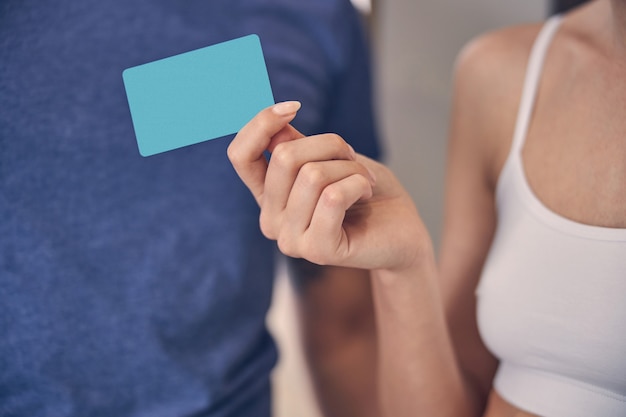 A close-up shot of a health insurance card held in someone's hand, with the insurance company logo and plan details visible.