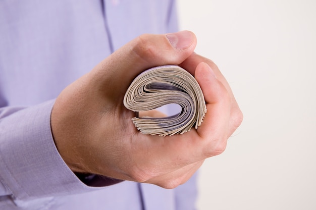 A close-up of a hand holding a U.S. Series I Savings Bond, with a background showing newspaper headlines about inflation and economic uncertainty.