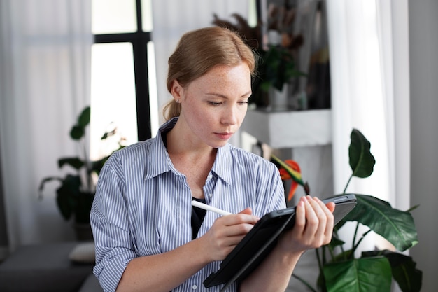 A person carefully reviewing the terms and conditions of a credit card rewards program on a digital tablet, with a notepad and pen nearby, indicating thorough analysis and planning.