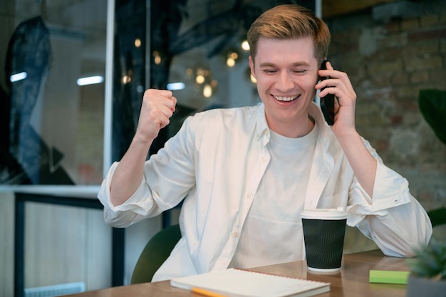 A person on the phone, smiling and gesturing positively, suggesting a successful negotiation with a lender. The image conveys the idea of effective communication leading to positive outcomes.