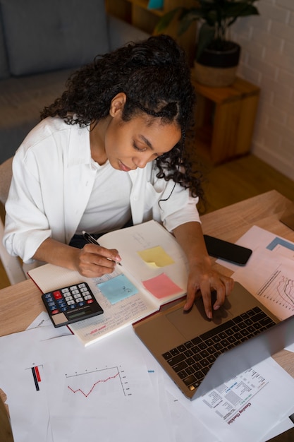 A person reviewing a budget spreadsheet on a laptop, with highlighted sections indicating areas for potential savings and expense reduction.
