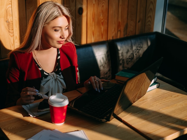 A person working on a laptop at a coffee shop, illustrating the concept of a flexible side hustle and earning extra income online.