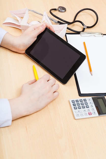 A close-up shot of a hand using a calculator, with various benefit plan documents scattered around, symbolizing the complexity of tax planning with employee benefits.