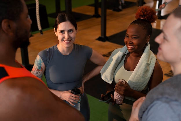 A diverse group of employees participating in a company-sponsored wellness program. They are engaged in activities such as yoga, healthy cooking demonstrations, and fitness challenges in a brightly lit and supportive environment.