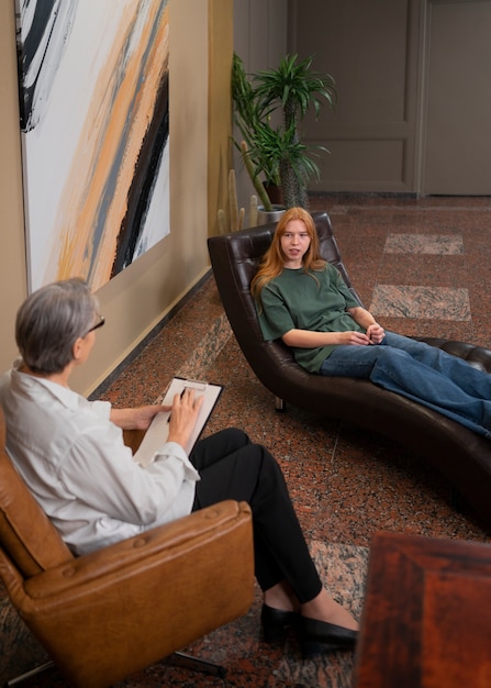 A therapist and an employee in a counselling session in a modern office. The therapist is showing empathy, and the employee is open to the session.