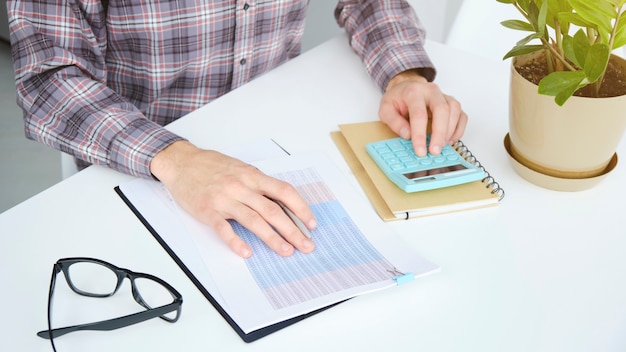 A person reviewing financial documents and using a calculator, with sticky notes indicating various tax deductions and credits.