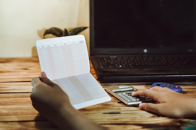 A close-up shot of a freelancer's hand using a calculator to determine quarterly estimated taxes, with a calendar and IRS tax forms in the background, emphasizing careful calculation and planning.