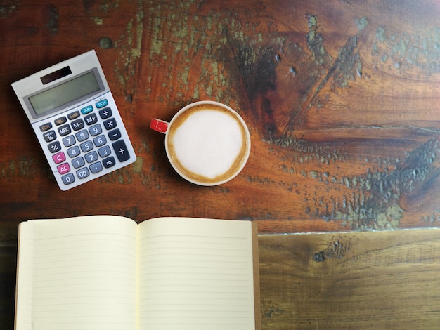 An overhead shot of various tax documents spread out on a desk, surrounded by pens, a calculator, and a mug of coffee, illustrating the process of preparing taxes before the filing deadline.