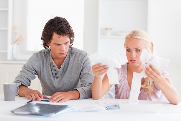 A family sitting at a table, reviewing their household budget and tax documents, illustrating the impact of tax changes on personal finances.