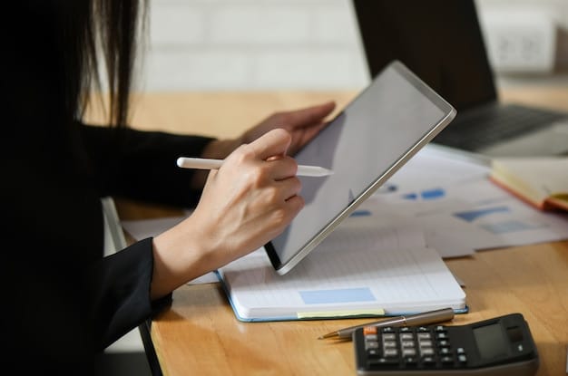 A person analyzing financial charts on a tablet, with a pen in hand, indicating focused research and planning. The background shows a modern office environment with financial articles and reports.
