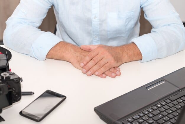 A close-up image of a human hand shaking on top of a table where a labor agreement is placed.