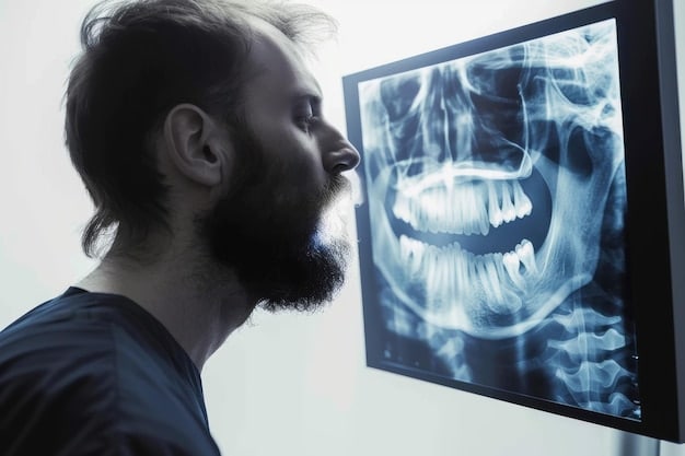 A close-up image of a dentist pointing to an x-ray of a patient's teeth, explaining the findings.