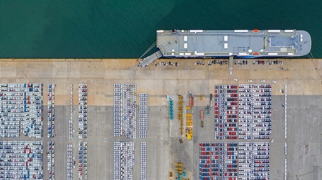 Depict an aerial view of a large shipping port congested with containers, emphasizing the logistical challenges and potential delays in global supply chains. The image should convey a sense of scale and complexity.