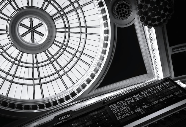 A zoomed image depicting the stock exchange board with a reflection of government house over it.