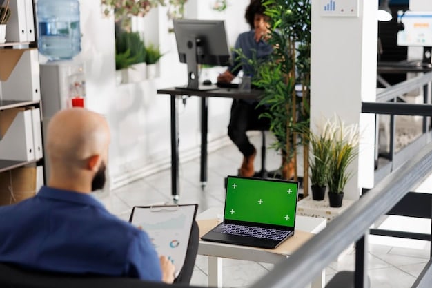 A modern office space with employees using laptops and tablets, accessing their benefits information online. The image should highlight the accessibility and flexibility of modern employee benefits platforms.