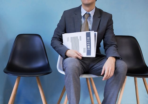 A person sitting accross from an HR represenative, pointing to a document with the company logo on it.